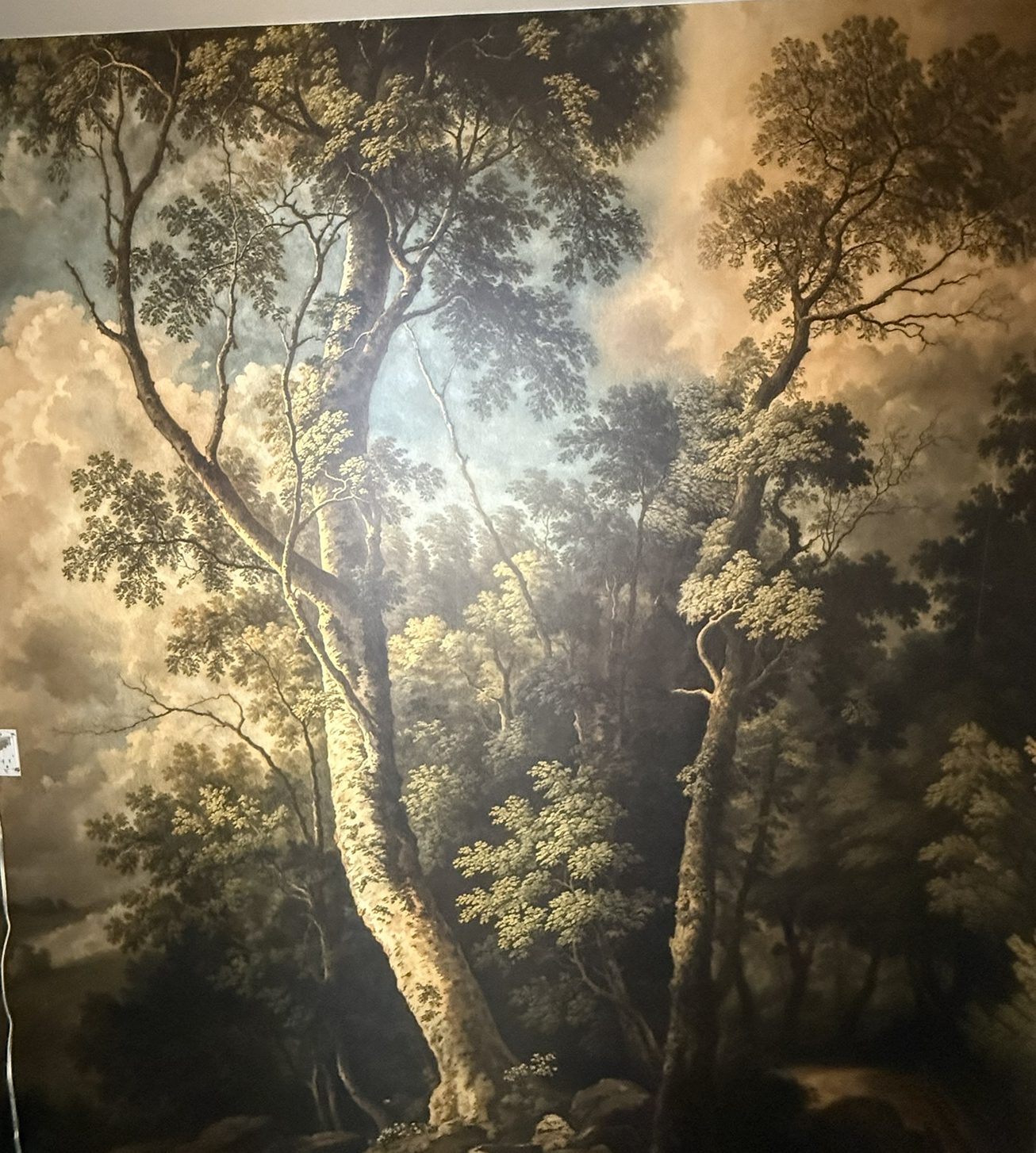 Old-masters scenic forest mural wrapping a powder room, sunlit tree at center