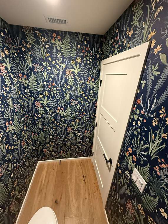 Dark botanical wallpaper in a powder room