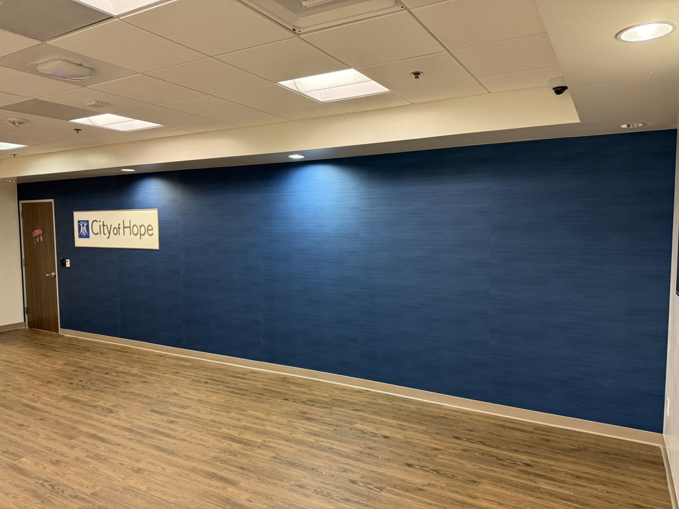 Deep blue textured wallcovering with the City of Hope logo in a healthcare office