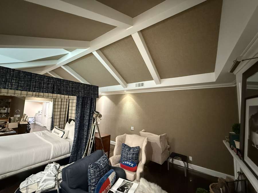 Grasscloth wallcovering between painted beams on a vaulted ceiling
